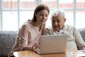Granddaughter helping grandfather on computer